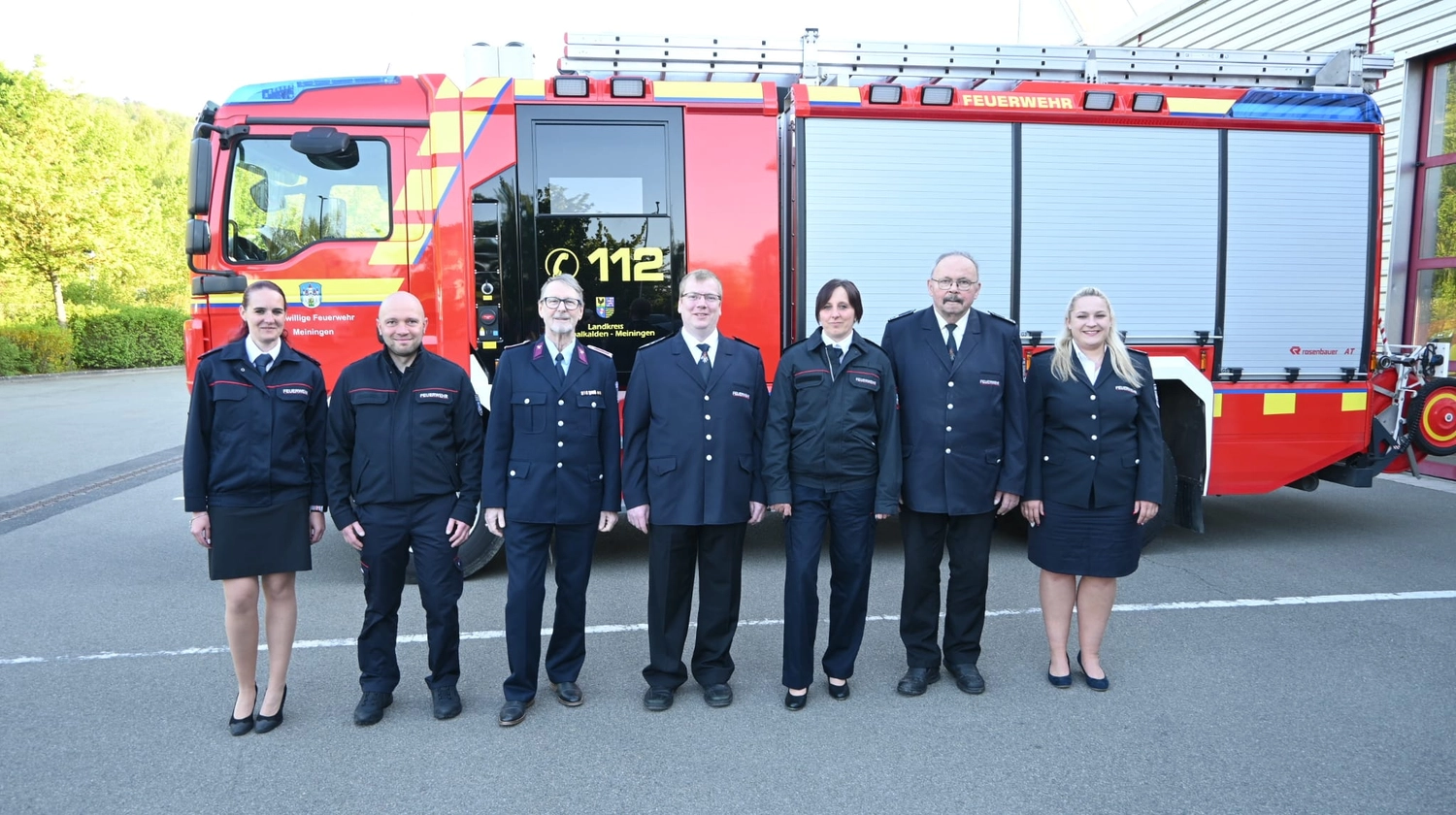 Krerisfeuerwehrverband Schmalkalden-Meiningen e.V. - Koordiniert die Aktivitäten und Veranstaltungen der Feuerwehr - Sieben Feuerwehrleute stehen vor einem roten Feuerwehrwagen