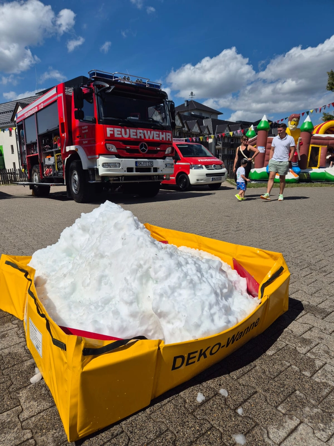 Kreisfeuerwehrverband Schmalkalden-Meiningen e.V. - Koordiniert die Aktivitäten und Veranstaltungen der Feuerwehr - Zwei junge Leute in dunkelblauen Feuerwehruniformen mit gelben Reflexstreifen bedienen einen Wasserschlauch während einer Übung im Freien.